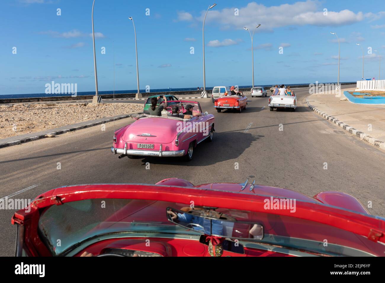 Colorful classic cars driving down the Malecon with blue sky in Havana Stock Photo
