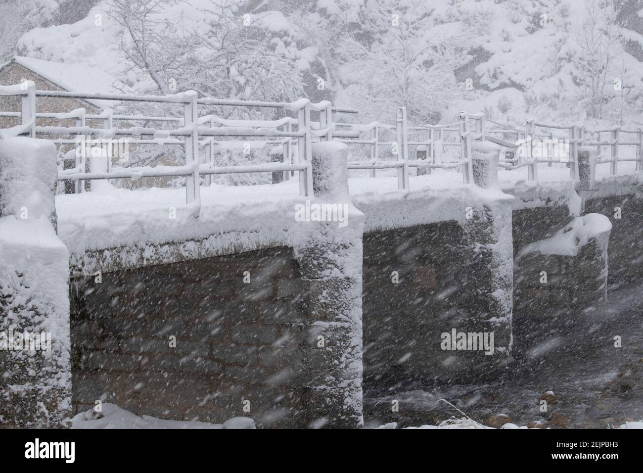 old bridge and riverbank in the middle of a snowfall Stock Photo - Alamy