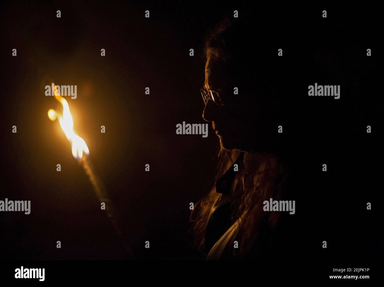 A penitent from Monte Calvario brotherhood holds a lighting torch during the Stations of the