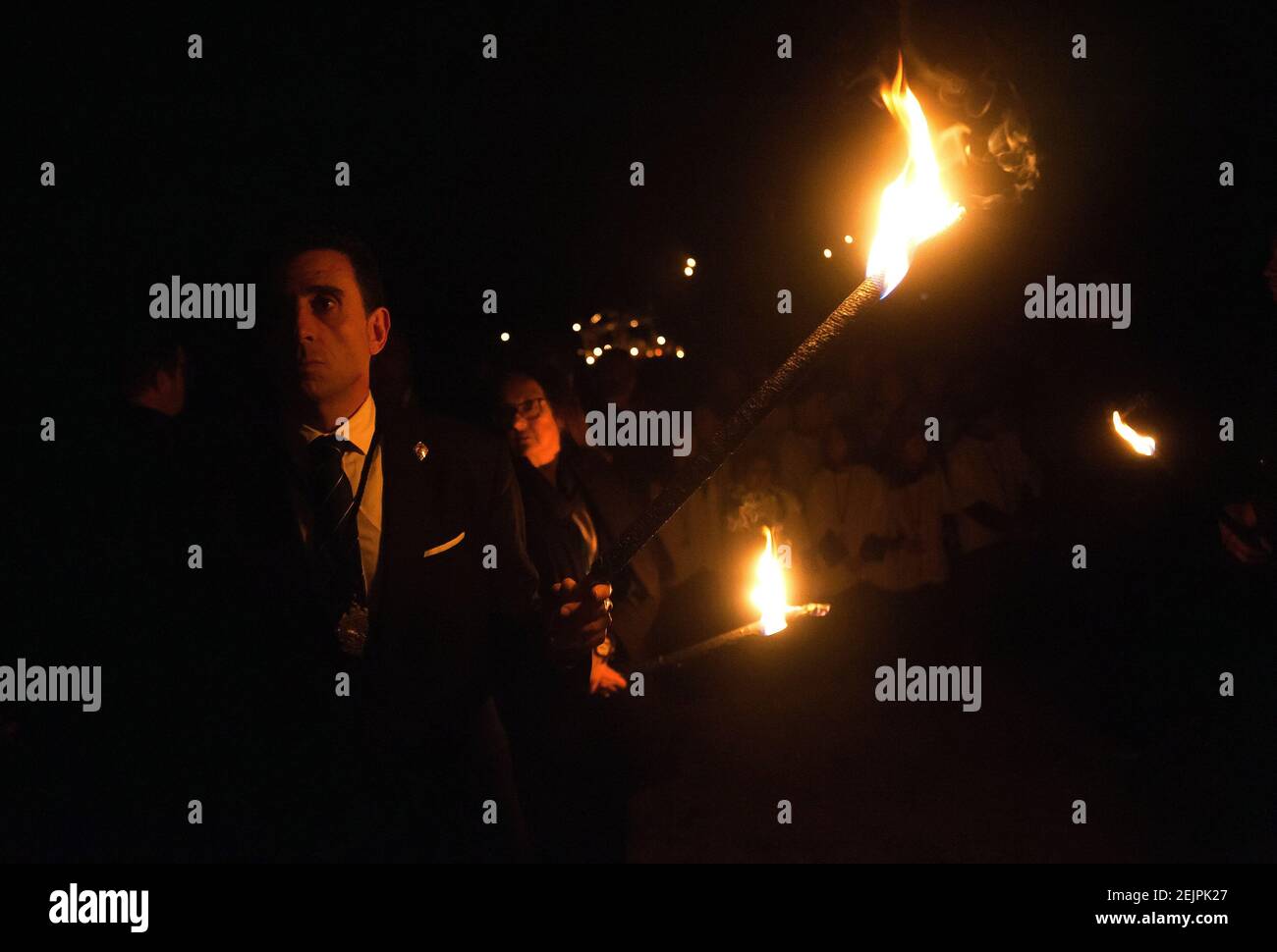 A penitent from Monte Calvario brotherhood holds a lighting torch during the Stations of the