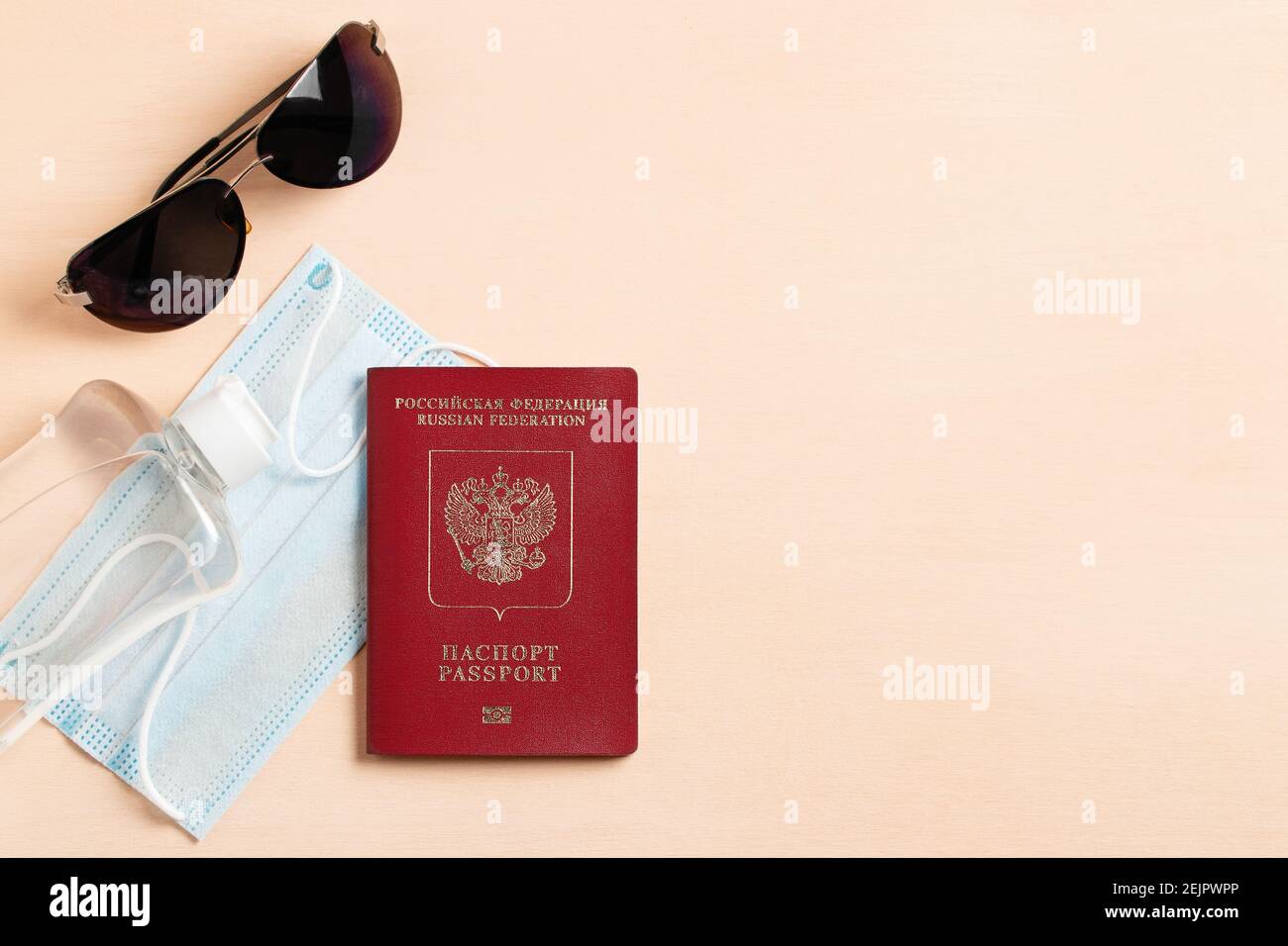 Safe travel during coronavirus pandemic concept. The inscription in Russian means passport and Russian Federation. Copyspace, flatlay. Stock Photo