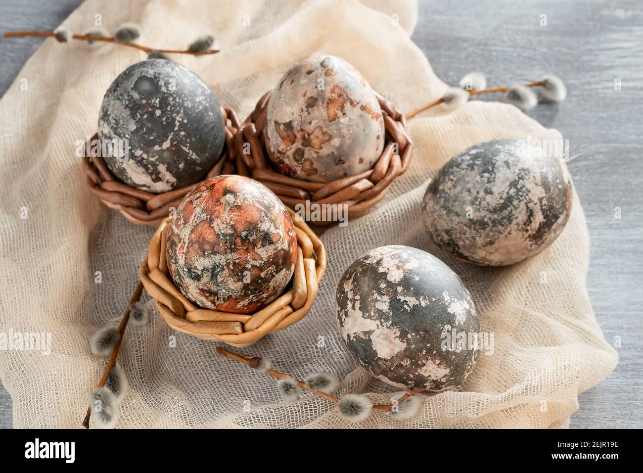 Easter composition - several marble eggs painted with natural dyes in a wicker baskets. Stock Photo