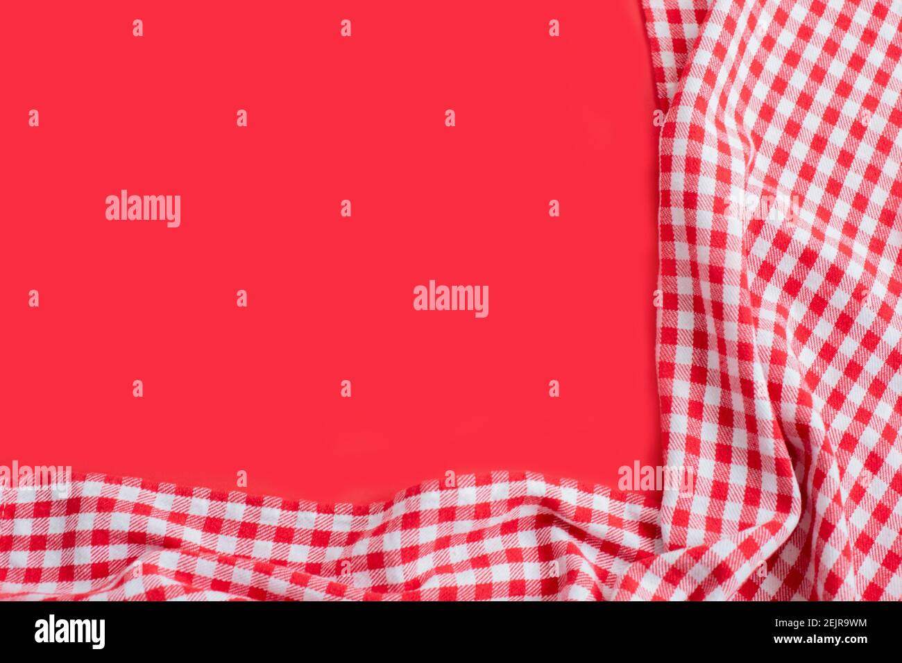 Red checkered tablecloth on a red background. Top view with copy space Stock Photo