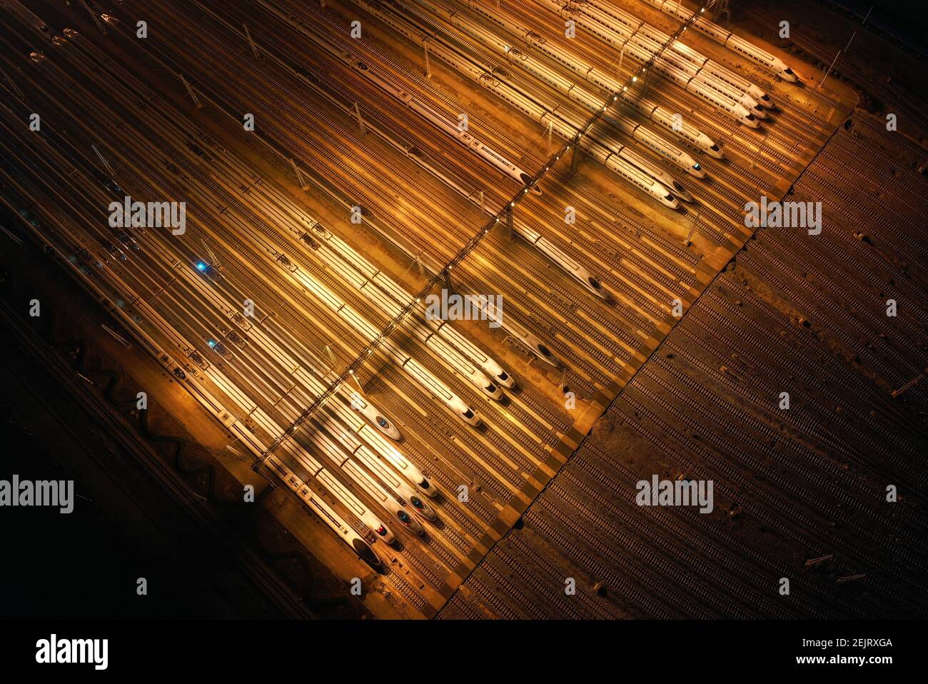 An aerial view of high-speed trains gathering at night after ...