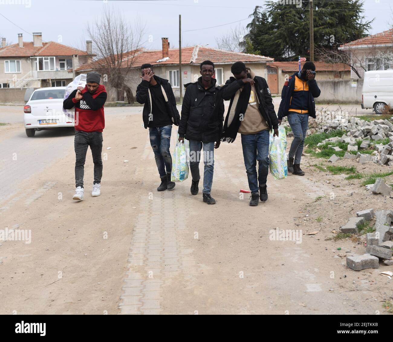A group of refugees walking on the road hide their faces. The humanitarian  crisis in Edrine, Turkey on the border with Greece is currently at a  standoff with approximately 6,000 refugees remaining