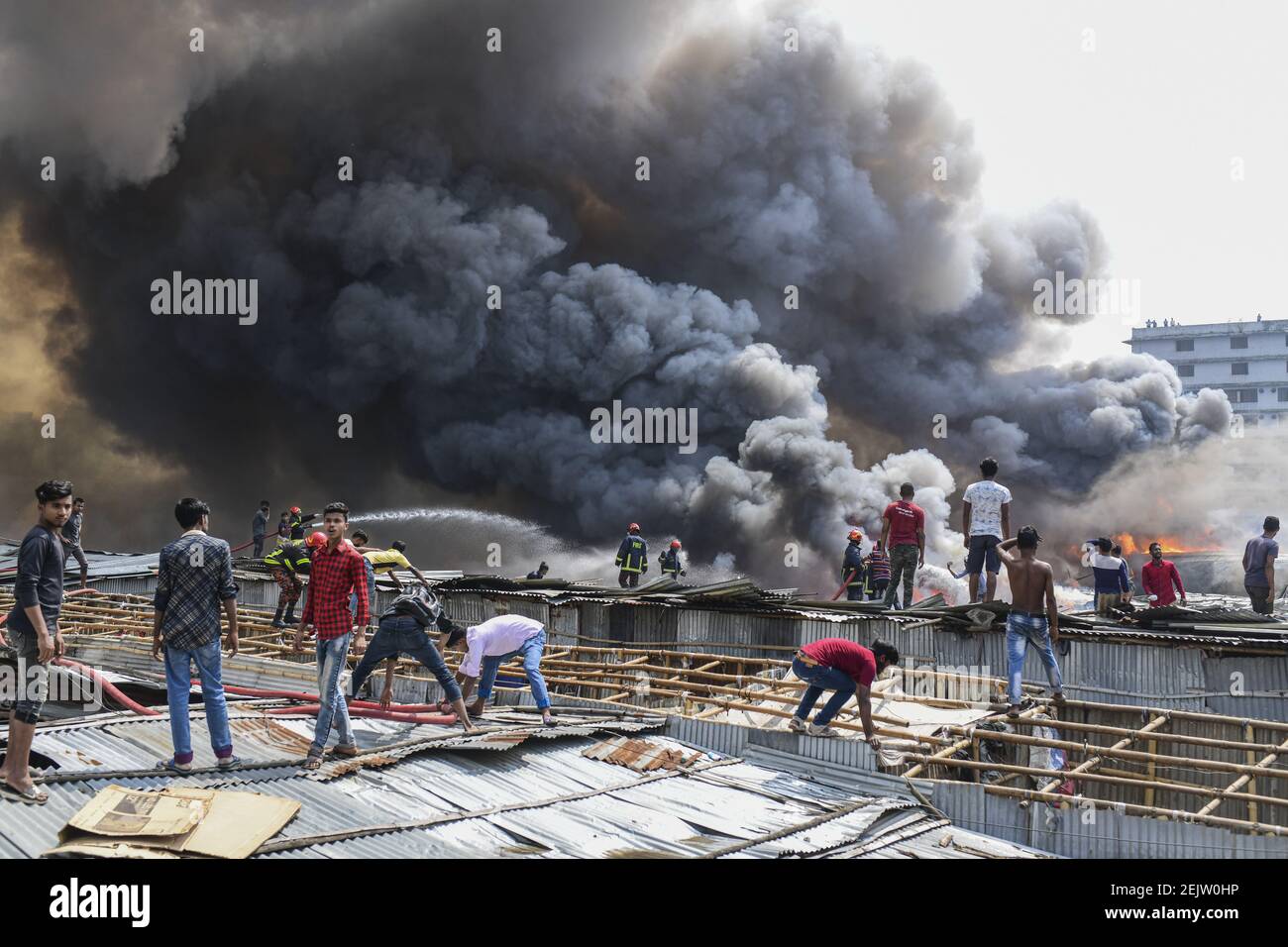 Smoke billows as firefighters work to extinguish a fire at a slum area ...