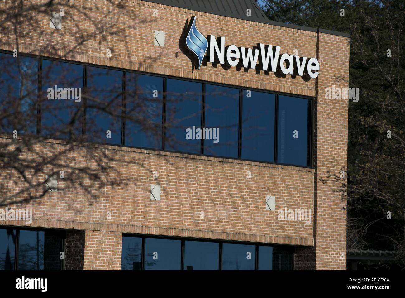 A logo sign outside of a facility occupied by NewWave Telecom ...