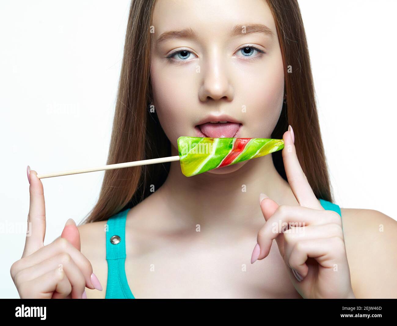 Teenager girl licking the lollipop. Sweet tooth concept. Stock Photo