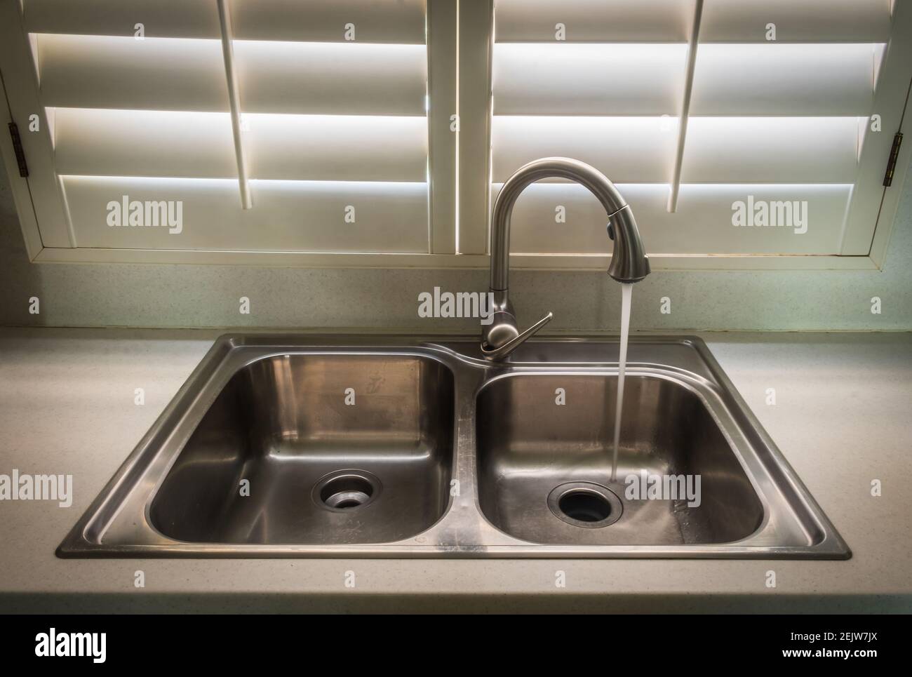 sink in a kitchen with running tap water Stock Photo