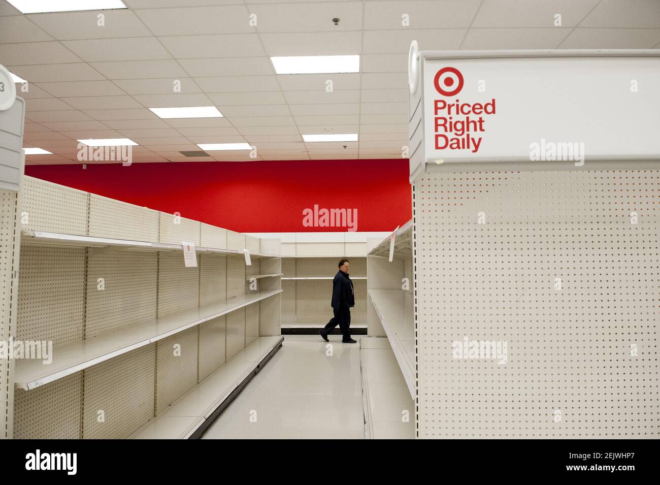 A man walks past aisles of empty shelves during these days of the COVID