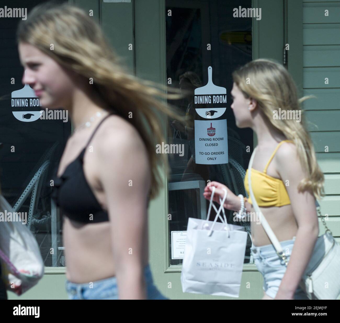 Mar 17, 2020; Seaside, FL, USA; Spring breakers walk past the doors of Rapido Pizza in Seaside, Fla.,as the restaurant closed all seating, offering only carry-out. Seaside imposed precautionary restrictions that blocked public beach access, close retail businesses, and limit restaurant seating due to coronavirus concerns. Mandatory Credit: Michael Snyder/The Northwest Florida Daily News via USA TODAY NETWORK/Sipa USA Stock Photo