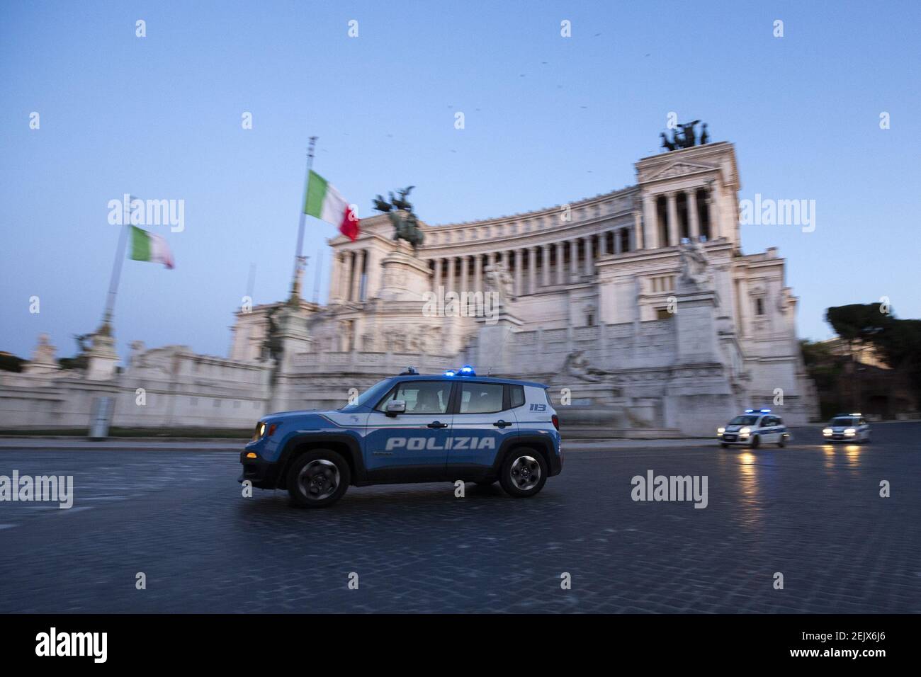 A police car pass in front of the Vittoriano in Piazza Venezia in Rome, Italy on March 23, 2020, during the 14th day of lockdown imposed nationwide by the Italian government that tries to tackle the coronavirus outbreak. Every movements in the citiies are restricted, and streets usually filled with life and traffic are almost empty (Photo by Giuseppe Fama/Pacific Press/Sipa USA) Stock Photo