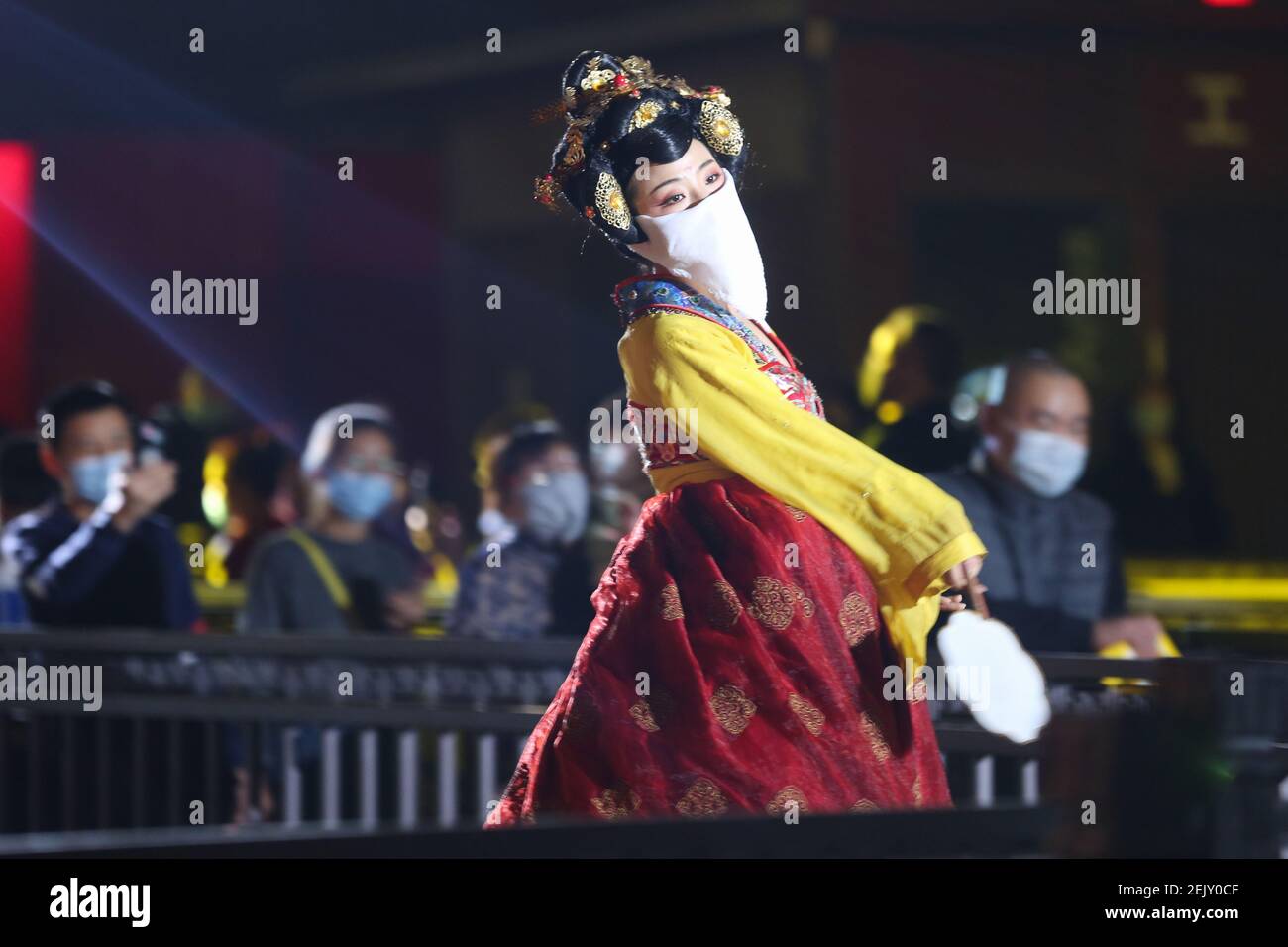 The Tumbler Girl, a dancer at a local tourist attraction called Grand Tang Dynasty Ever Bright City, performs for tourists with face mask on, Xi'an city, northwest China's Shaanxi province, 21 March 2020. Stock Photo