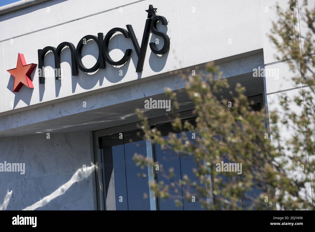 A logo sign outside of a Macy's retail store location in Fredericksburg
