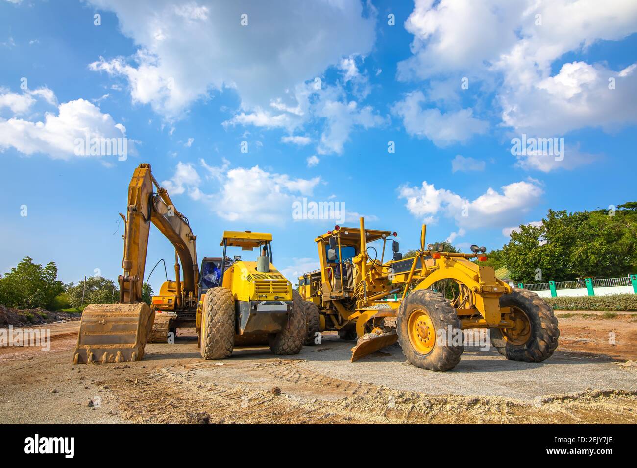 Backhoe, grader and road roller on the ground at site construction