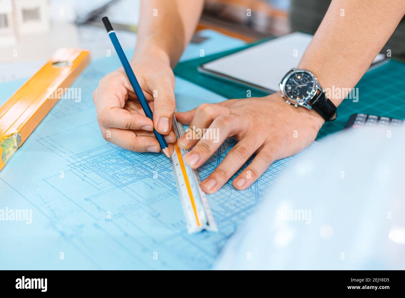 engineers holding a pen pointing to a building and drawing outlay