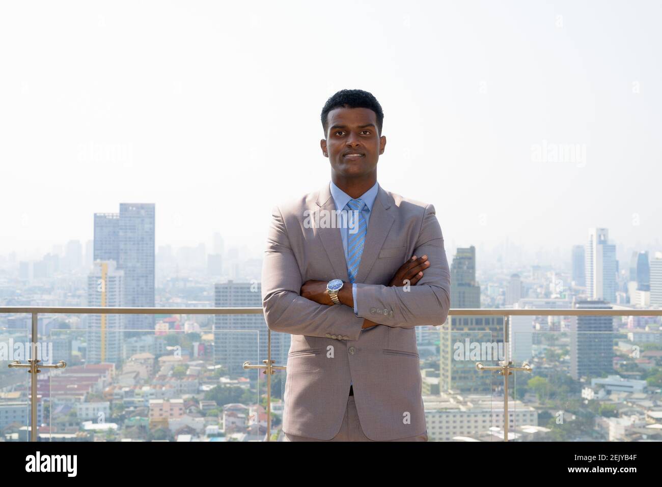 Portrait of handsome young African businessman wearing suit and smiling ...
