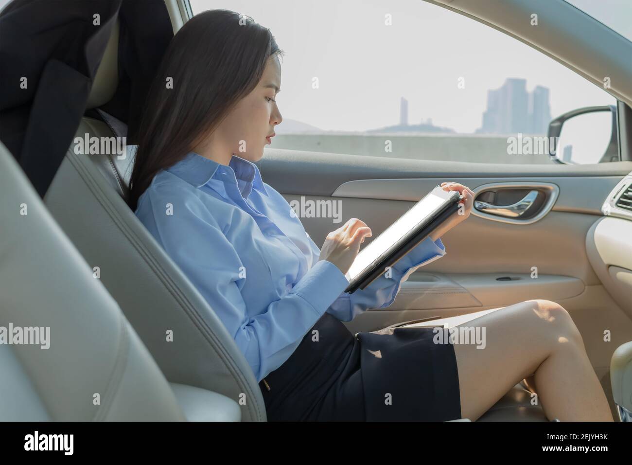 Businesswoman inside a car using a tablet for working. Stock Photo
