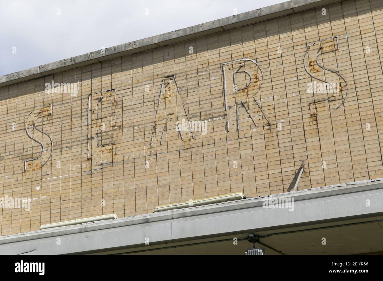 The faded outline of a logo sign outside of a closed and abandoned