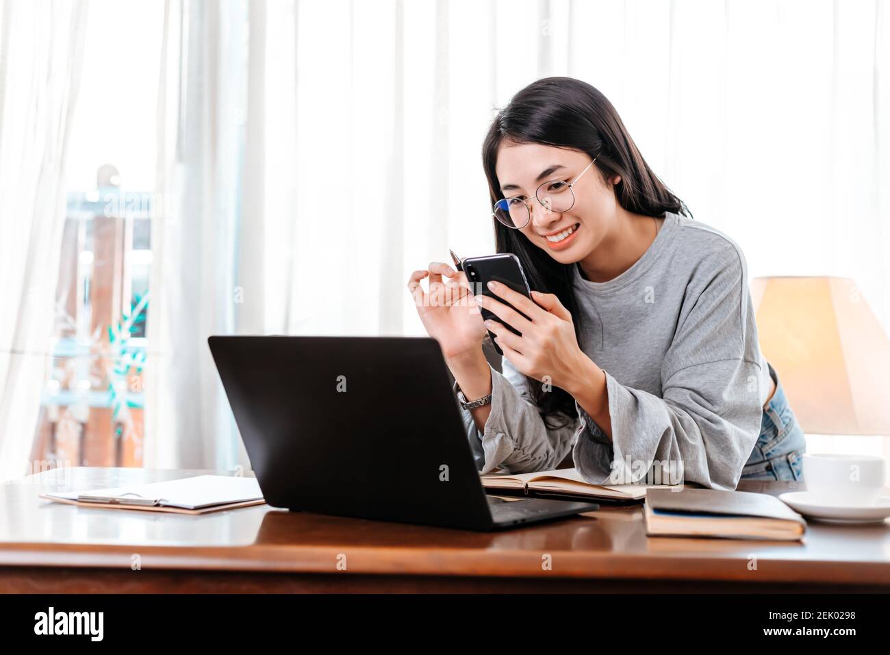woman using mobile phone while working at home. Businesswoman working concept. Stock Photo