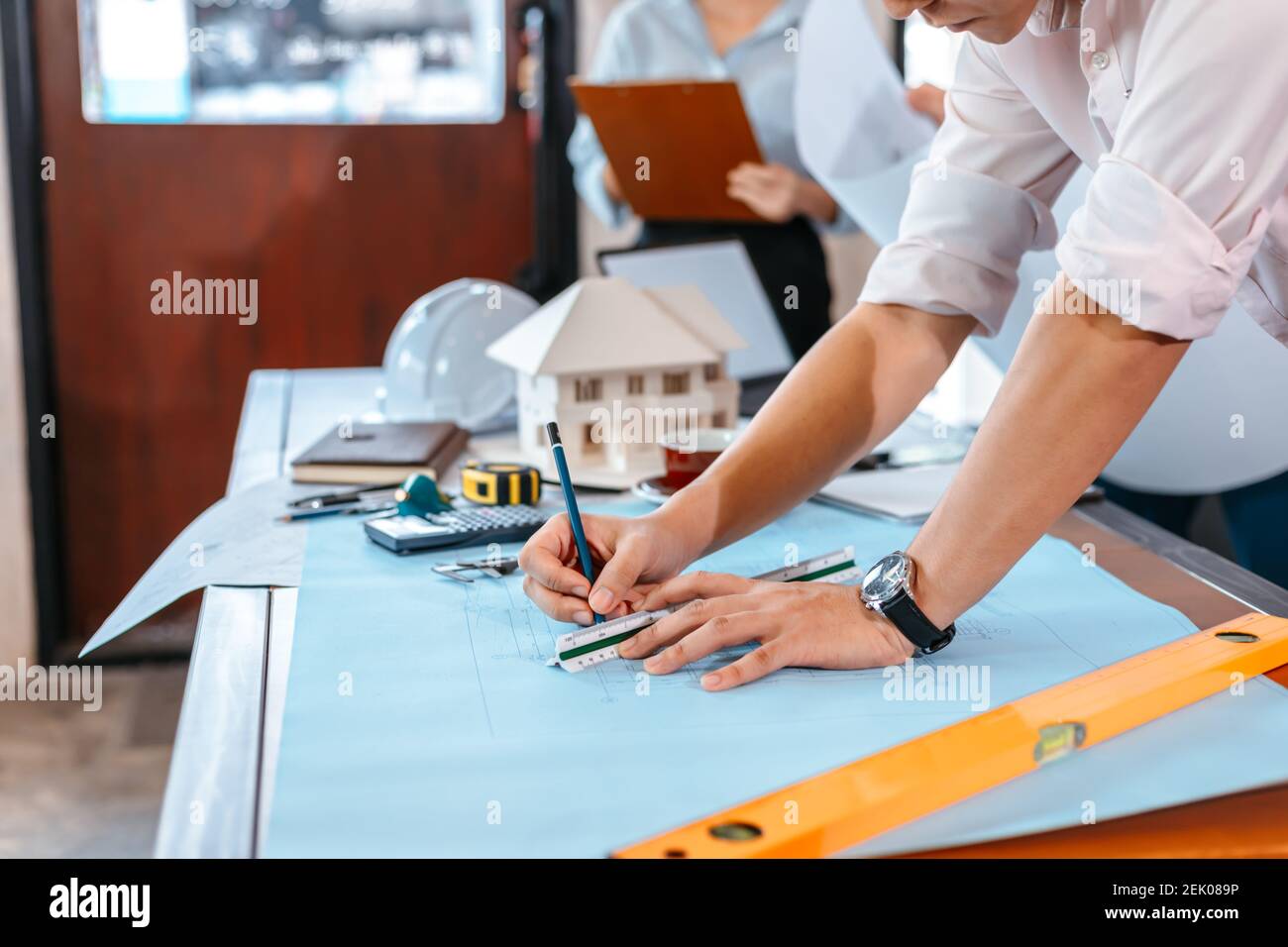 engineers holding a pen pointing to a building and drawing outlay
