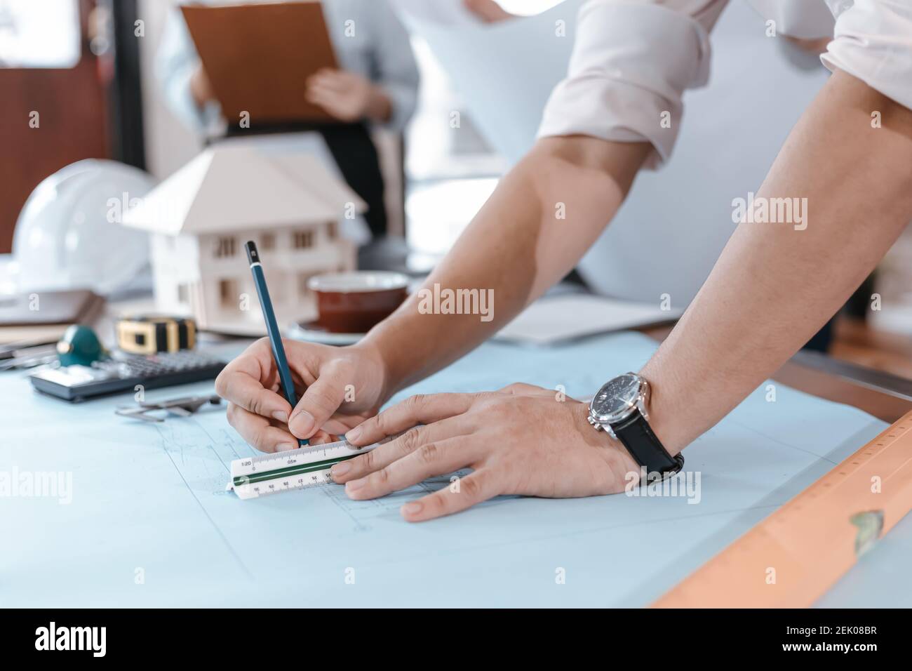 engineers holding a pen pointing to a building and drawing outlay ...