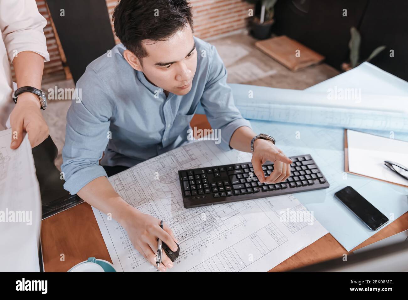 Architect reading building and drawing outlay construction plan as ...