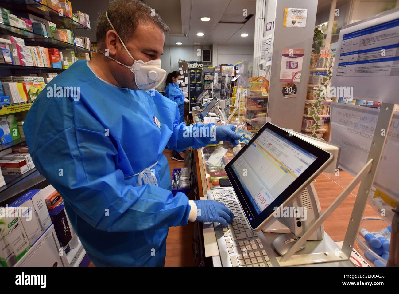 A pharmacist checks a citizens health card in order to receive a free mask  provided by the Government of Catalonia in a pharmacy. The pharmacies of  Catalonia (Spain) today began to distribute