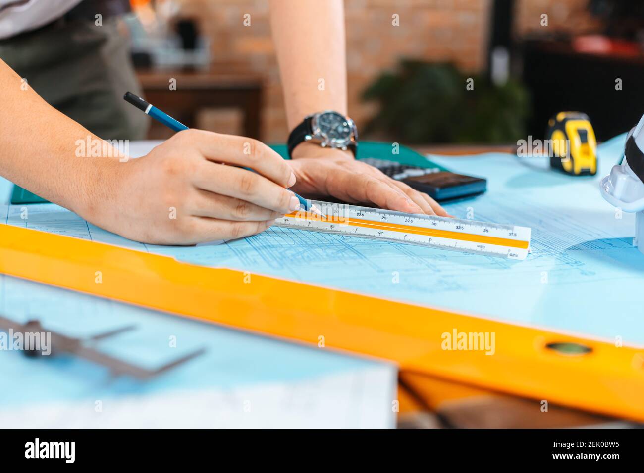 engineers holding a pen pointing to a building and drawing outlay