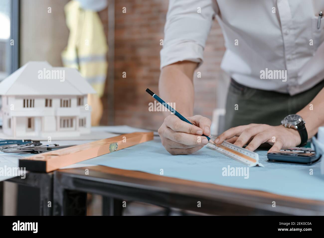 engineers holding a pen pointing to a building and drawing outlay ...