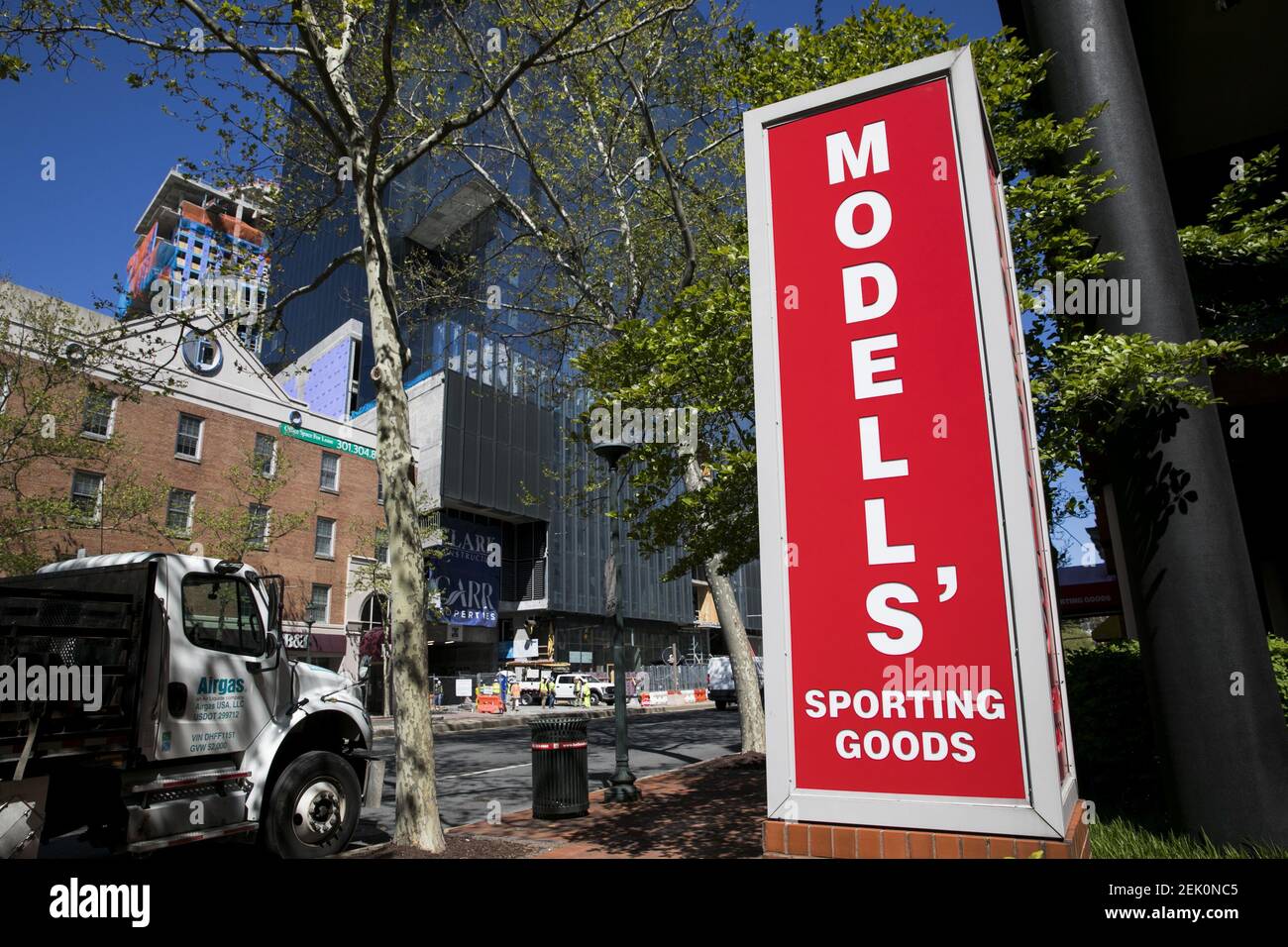 A logo sign outside of a Modell's Sporting Goods retail store location