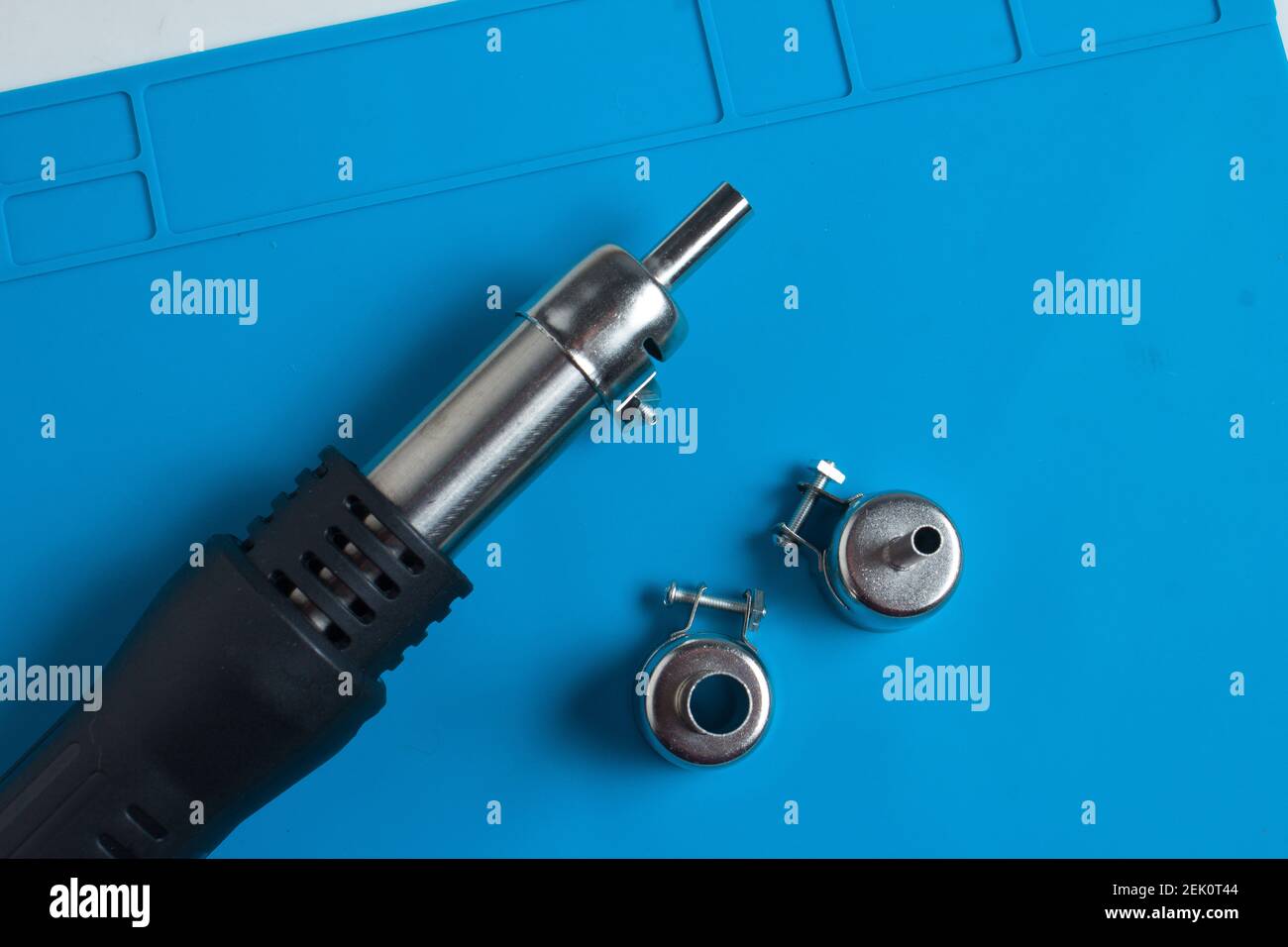 Hot air gun for soldering, and additional attachments to it, on the background of a blue mat Stock Photo