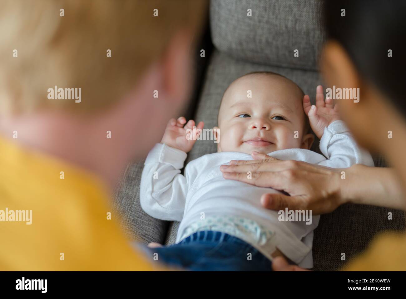 happy mother, father with baby playing together at home. Family, parent and baby concept. Stock Photo