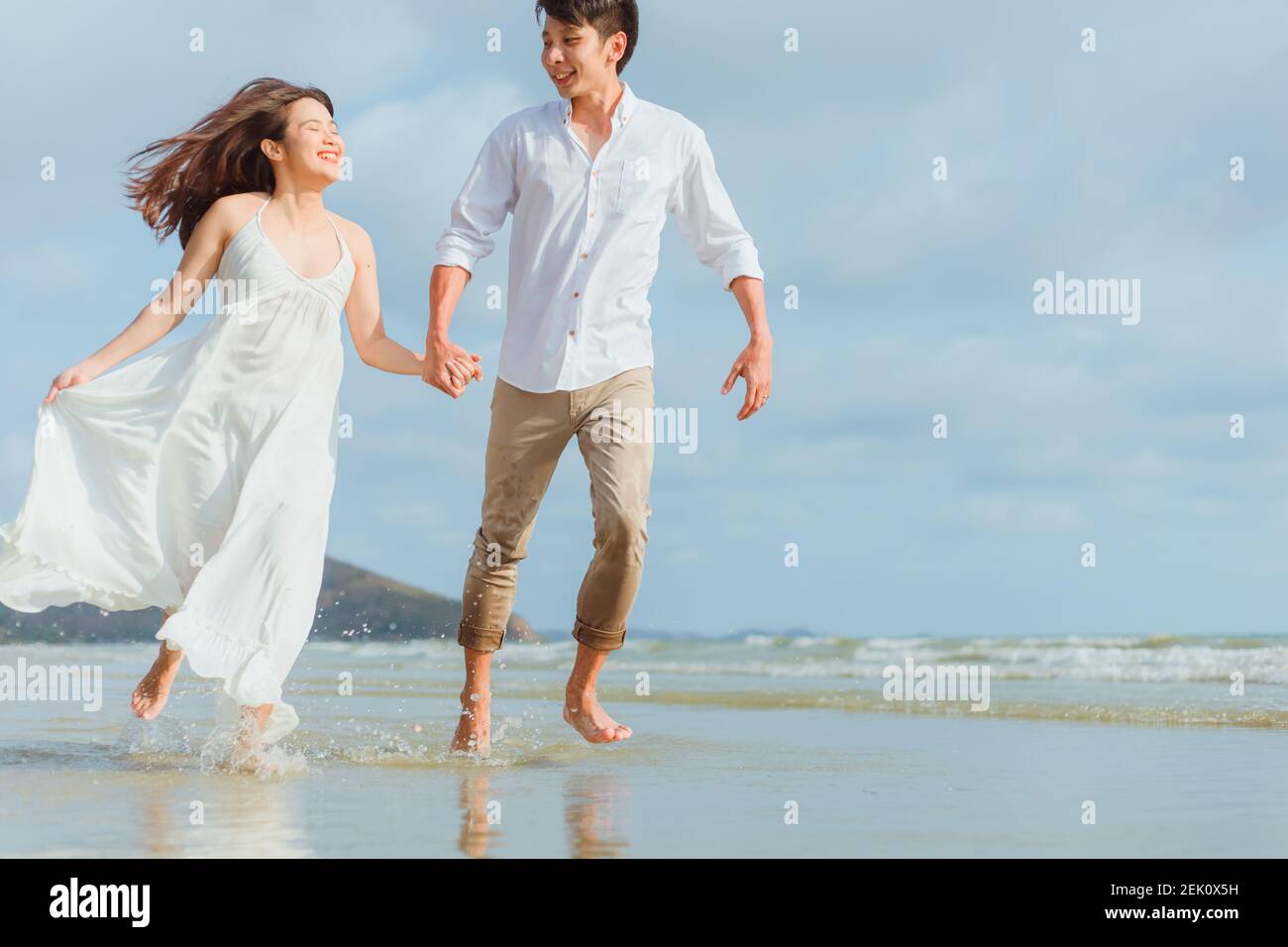 Love young couple holding hands and running on the beach. Holiday and ...