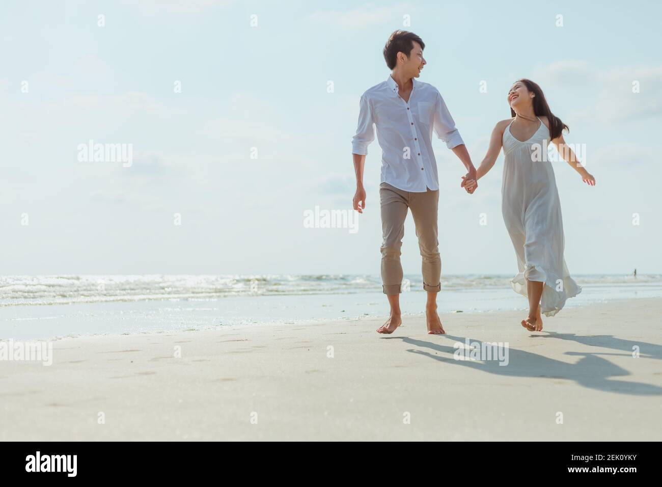 Love young couple holding hands and running on the beach. Holiday and ...