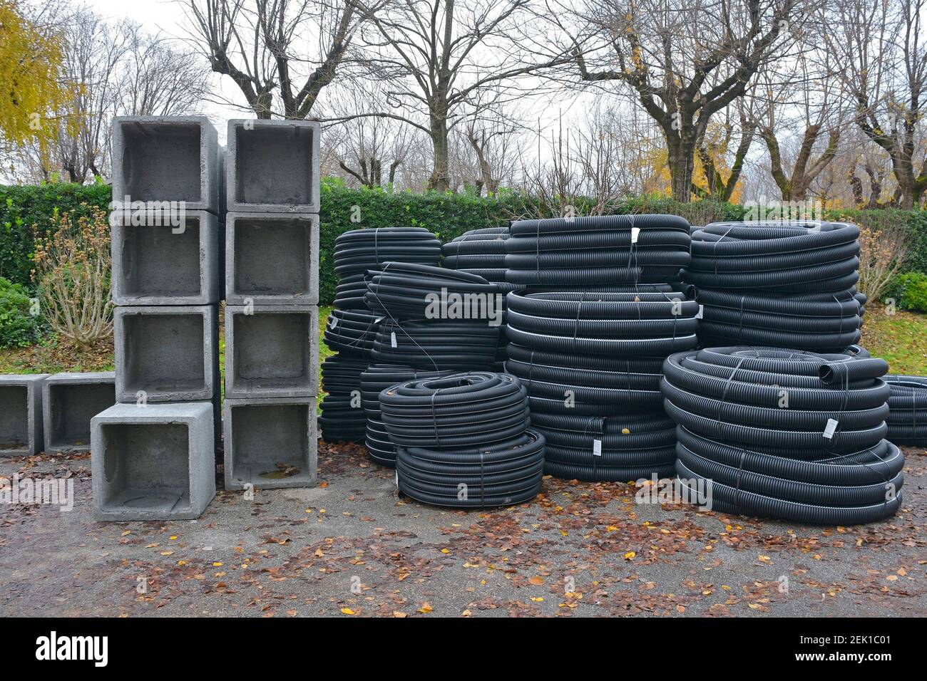 Reinforced concrete square box culverts and rolls of black corrugated flexible drain pipes on a construction site in north east Italy Stock Photo