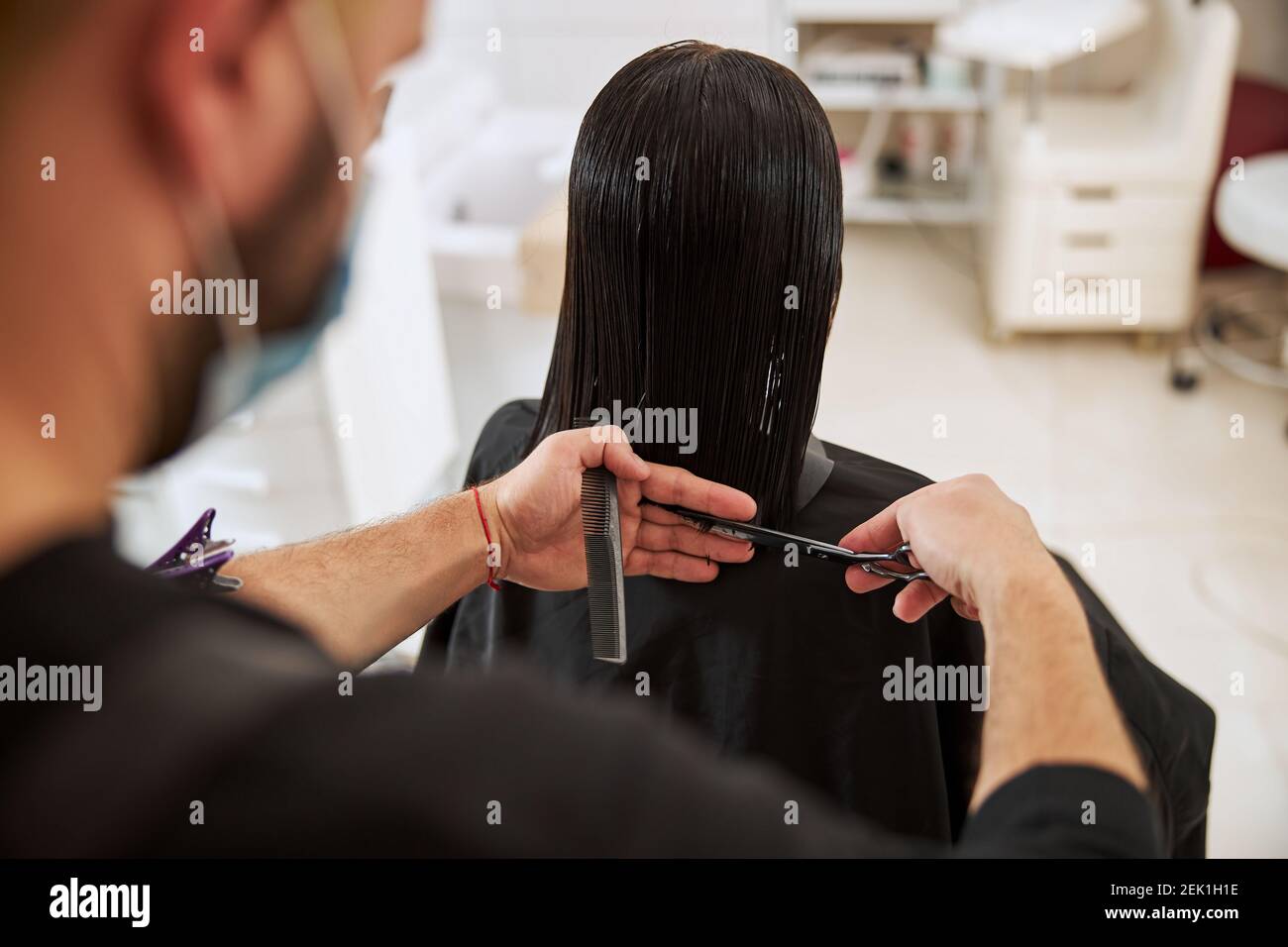 Female having her hair trimmed by a coiffeur Stock Photo Alamy