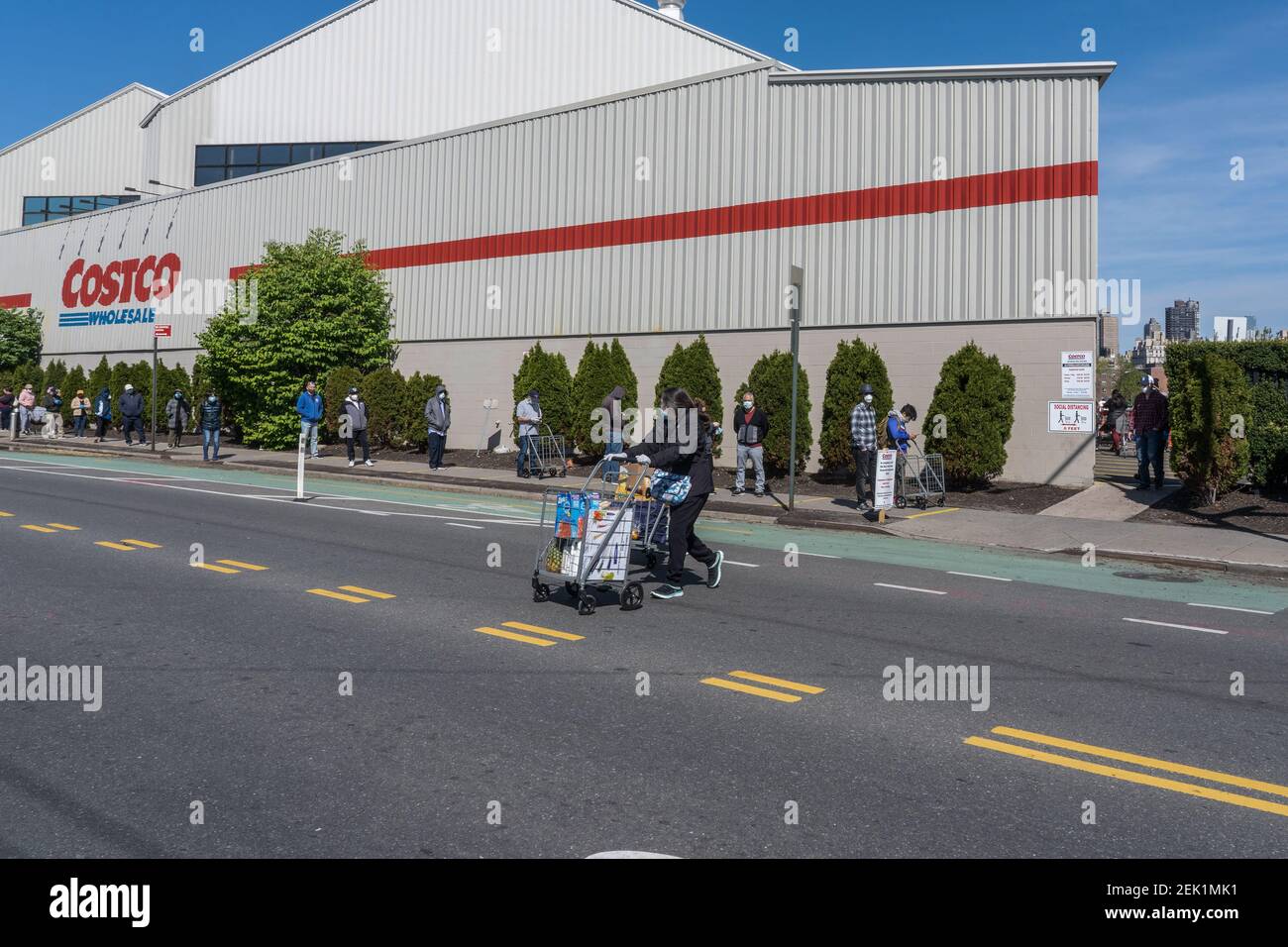 A queue of people at a social distance for free face masks widens