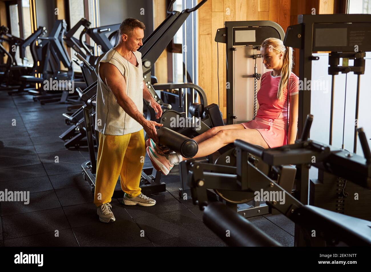 Tall fit lady using leg extension machine at the gym Stock Photo Alamy