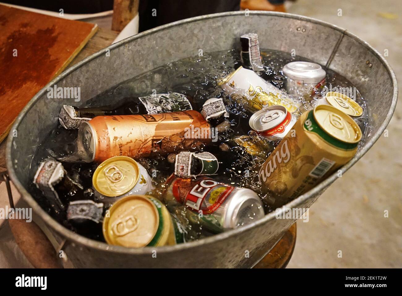 A tin container bowl of iced beer cans and alcohol liquor drink bottles