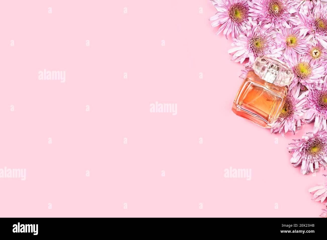 Fresh spring flowers and perfume. Pink background for advertising
