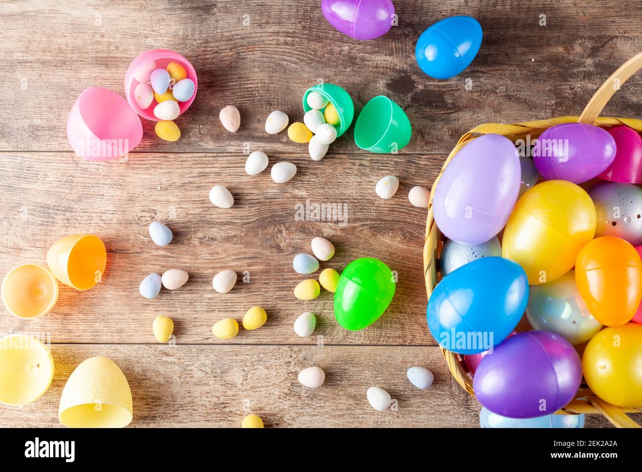 Flat lay image of plastic easter eggs being filled with chocolates before easter egg hunt. It is a fun activity for children who search for eggs and g Stock Photo