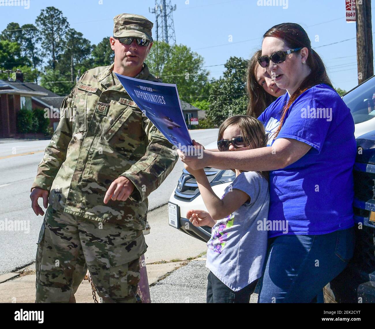 Apr 27, 2020; Anderson, SC USA; Tech Sgt. Gregory, Swamp Fox production recruiter, gives a poster of an F-16 to Jessica Hubbart and her daughter Reagan, middle, before planes flew over AnMed Health in Anderson Monday, April 27, 2020. Operation American Resolve, The South Carolina Air National Guard's Airmen of the 169th Fighter Wing flew over AnMed Health and hospitals around the state. The group stated they 'are humbled by the sacrifices made from our first responders and healthcare professionals. As our jets return from a training mission late Monday morning, 27 April, our six-ship formatio Stock Photo