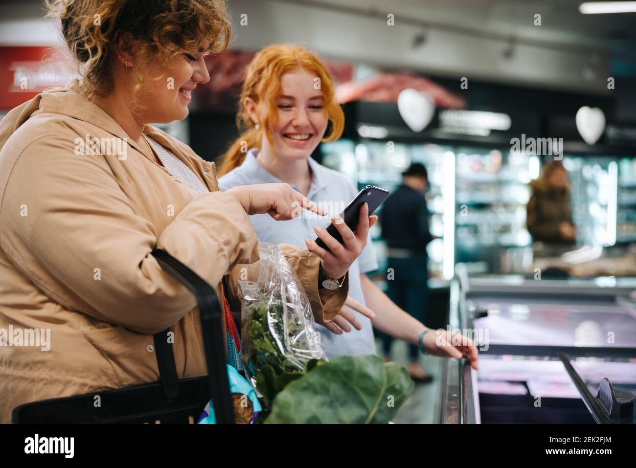 Shopper asking for help from a female worker in grocery store. Shopper
