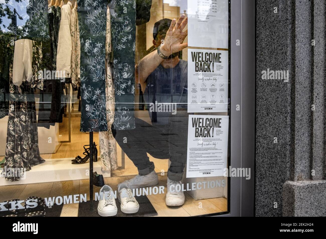 A seller of the IKKS clothing store is seen placing welcome signs in the  shop window during Phase Zero of the breakdown of confinement due to the  Covid-19 pandemic. After 60 days