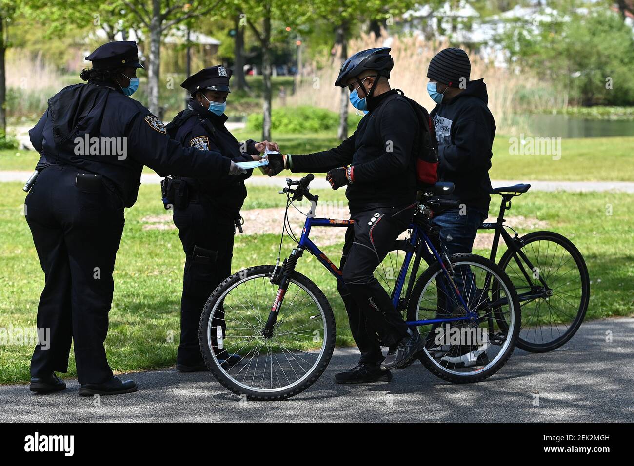 NYPD School Safety officers hand out masks to cyclist in Baisley Pond