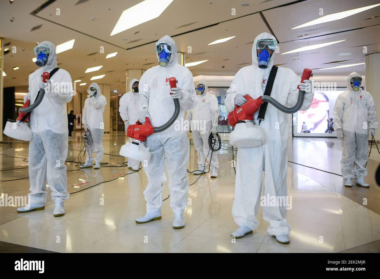 Workers wearing protective suits disinfect the Siam Paragon shopping