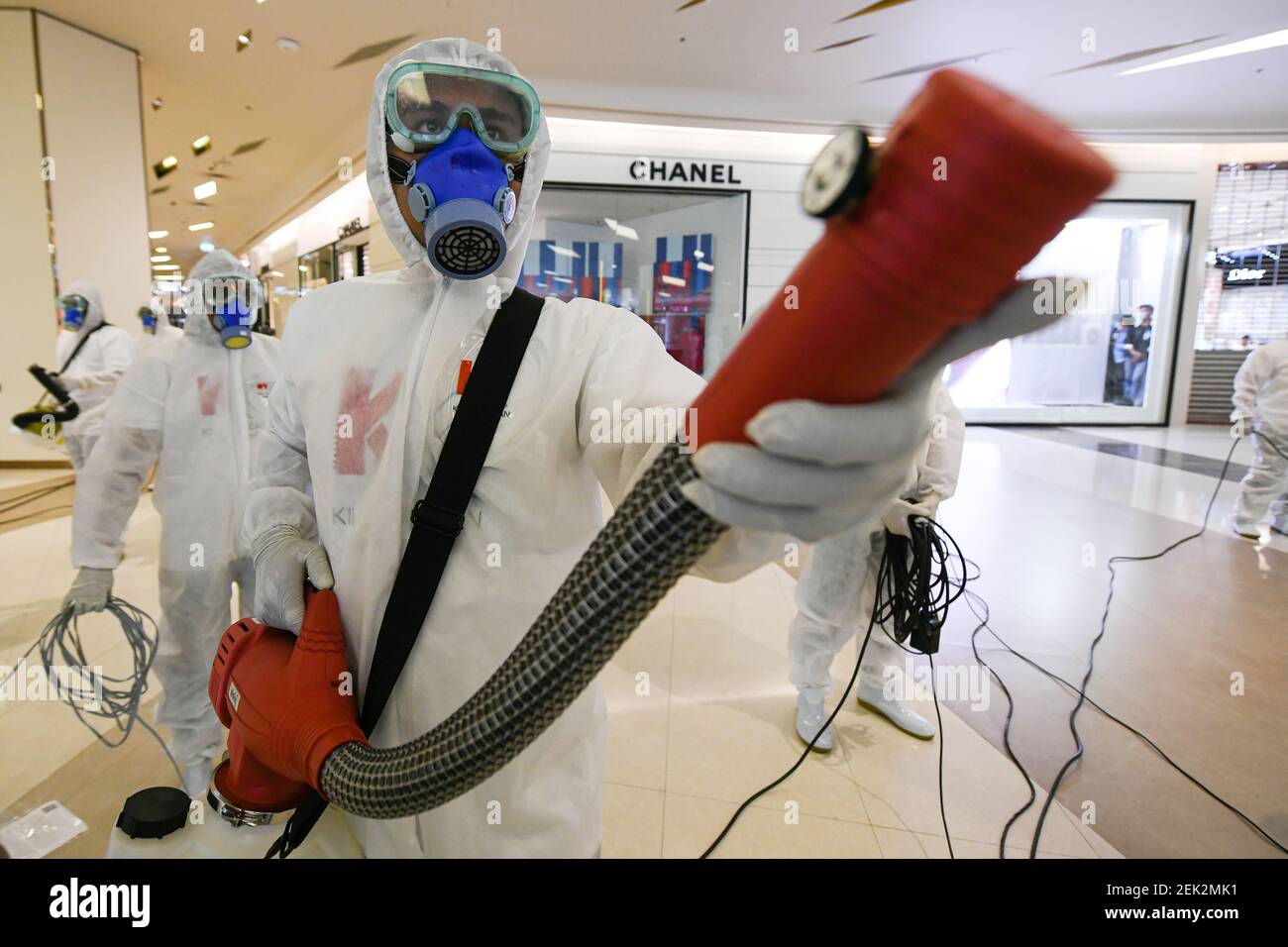 Workers wearing protective suits disinfect the Siam Paragon shopping