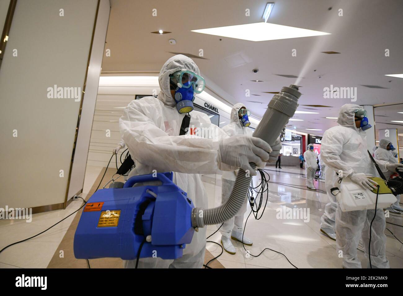 Workers wearing protective suits disinfect the Siam Paragon shopping