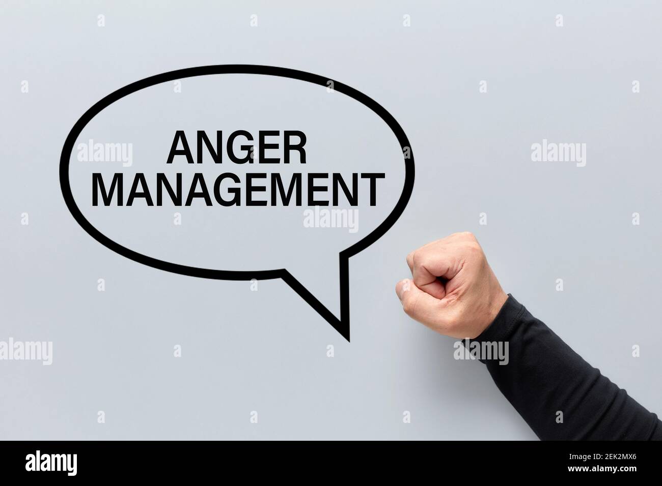 The word anger management written in a speech balloon with an angry male fist. Managing anger concept. Stock Photo